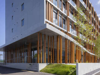 Discover modern living in this architecturally stunning building, featuring a unique facade with vertical wooden beams and expansive concrete elements.
