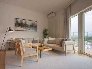 Experience modern living in this spacious apartment featuring a comfortable sectional sofa and elegant armchairs, perfect for relaxation.