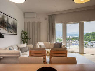 Experience modern living in this spacious living area, featuring a comfortable sectional sofa and a striking abstract artwork.