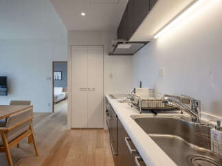 Experience modern living in this beautifully appointed kitchen, featuring sleek cabinetry and a spacious sink area perfect for meal preparation.
