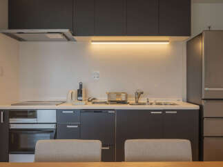 Discover this modern kitchen featuring sleek dark cabinetry and a convenient built-in oven and stovetop.
