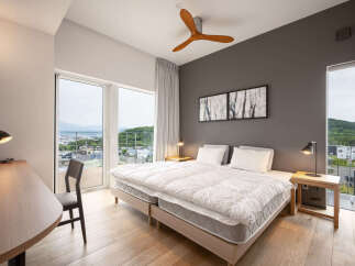 Experience modern comfort in this beautifully appointed bedroom, featuring a spacious king-sized bed with plush white linens.