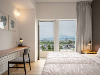 Experience breathtaking panoramic views from this stunning bedroom, featuring a spacious balcony perfect for enjoying the scenery.