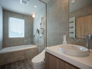 Experience modern comfort in this beautifully designed bathroom, featuring a sleek bathtub and shower combination.