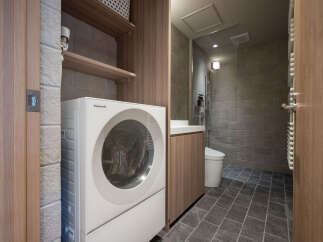 Discover modern convenience in this compact bathroom featuring a Panasonic washing machine and a sleek vanity.