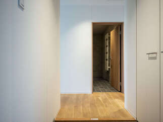 Step into a modern hallway featuring warm wooden floors and a sleek, minimalist design.