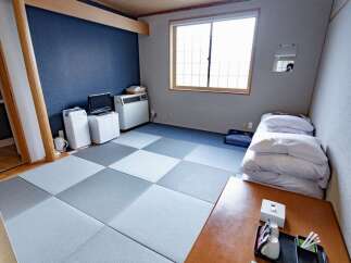 Experience traditional Japanese living in this serene room featuring tatami flooring and a comfortable futon bed.