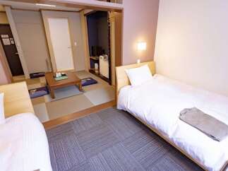 Experience a blend of traditional Japanese and modern comfort in this hotel room.