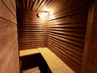 Experience ultimate relaxation in this private sauna, featuring warm wooden interiors and comfortable seating.