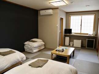 Experience comfort and tranquility in this Japanese-style room, featuring two twin beds and a traditional futon set.