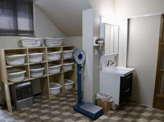 Discover a practical and organized space featuring ample storage with multiple white laundry baskets neatly arranged on shelves.