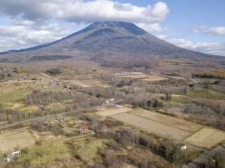 Discover serene rural living with this stunning aerial view of a property nestled amidst rolling hills and agricultural fields.