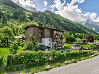 Experience the charm of alpine living in this stunning property nestled against a backdrop of majestic mountains and lush greenery.