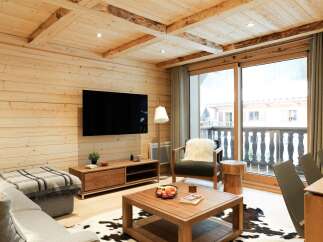 Experience rustic charm in this inviting living space, featuring warm wood paneling and exposed beams on the ceiling.