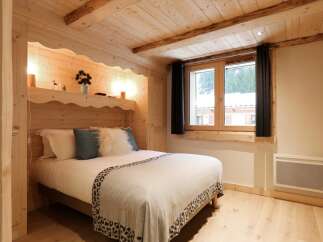 Experience cozy mountain living in this charming bedroom featuring a comfortable bed with plush pillows and a decorative throw.