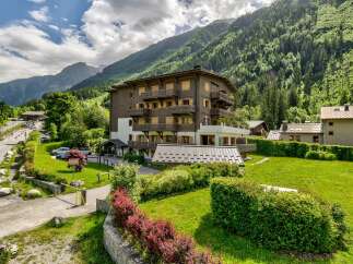 Experience the charm of alpine living in this stunning property nestled against a backdrop of lush green mountains.