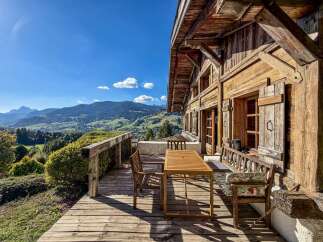 Experience breathtaking mountain views from this charming wooden chalet's expansive deck.