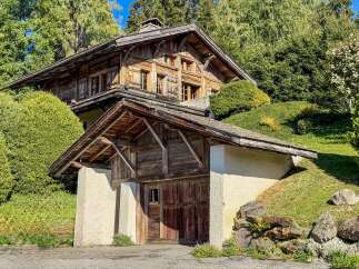 Discover this charming rustic wooden chalet nestled amidst lush greenery and mature trees.