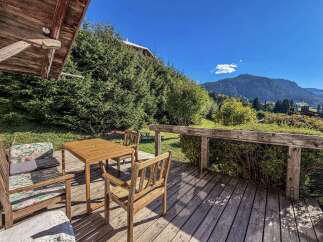 Enjoy breathtaking mountain views from this charming wooden deck, perfect for outdoor dining and relaxation.