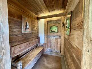 Step into a rustic entryway featuring warm wooden paneling throughout, creating a cozy and inviting atmosphere.