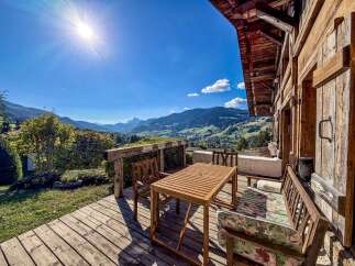 Enjoy breathtaking mountain views from this charming wooden deck, perfect for outdoor dining and relaxation.