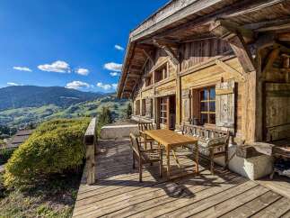 Experience breathtaking mountain views from the expansive wooden deck of this charming alpine chalet.