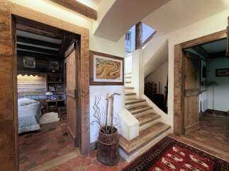 Step into a charming rustic entryway featuring exposed wooden beams and a beautiful terracotta tile floor.