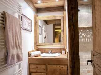 Experience rustic charm in this mountain-style bathroom, featuring a wooden vanity with a vessel sink and a large mirror.