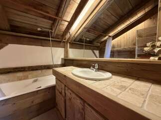 Experience rustic charm in this bathroom featuring a deep soaking tub and a spacious vanity with a vessel sink.