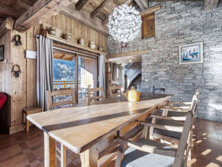 Experience rustic charm in this mountain chalet dining area, featuring a large wooden table perfect for family gatherings.