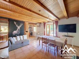 Experience rustic charm in this inviting living and dining area, featuring a striking stag mural and exposed wooden beams that create a cozy mountain lodge ambiance.