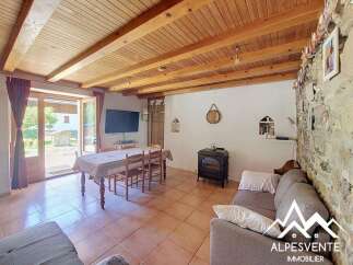 Experience rustic charm in this inviting living space, featuring a cozy wood-burning stove and a dining area perfect for family meals.