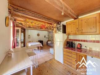 Discover this charming rustic kitchen featuring warm wooden cabinetry and a cozy dining area.