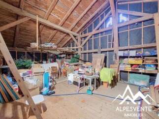 Discover this spacious attic with exposed wooden beams, offering ample storage and potential for conversion.