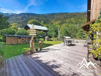 Experience the charm of this alpine property, featuring a spacious wooden deck perfect for outdoor entertaining and enjoying the serene mountain views.