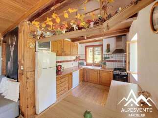 Discover this charming rustic kitchen featuring warm wooden cabinetry and a cozy dining area perfect for family meals.
