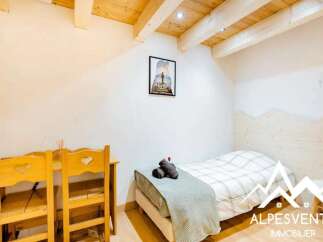 This charming room features a cozy single bed with a plaid comforter, perfect for a relaxing stay.