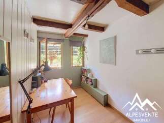 Discover this charming room featuring exposed wooden beams and a cozy workspace.