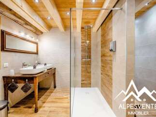 Experience rustic charm and modern luxury in this stunning bathroom featuring a double vanity with vessel sinks atop a vintage wooden table.