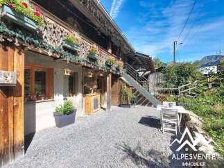 Charming alpine property featuring a rustic wooden facade adorned with flower boxes and intricate carvings.