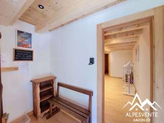 Step into a charming mountain retreat featuring rustic wooden beams and a cozy entryway.