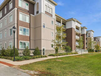 Discover modern living in this stunning multi-story apartment building, featuring a sophisticated blend of brown and beige siding with elegant architectural details.
