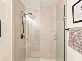 Experience modern luxury in this beautifully appointed bathroom, featuring a spacious walk-in shower with sleek glass doors and elegant tiled walls.