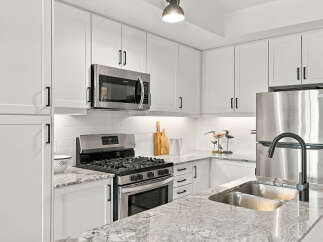 Experience modern living in this stunning kitchen featuring sleek white cabinetry and a durable granite countertop.