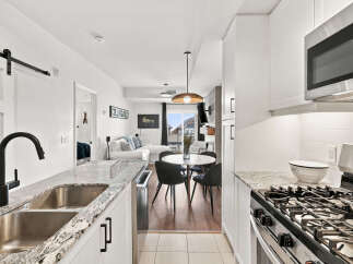 Experience modern living in this bright and airy kitchen, featuring sleek granite countertops and a convenient double sink with a stylish black faucet.