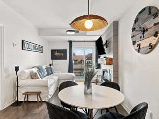 Experience modern living in this stylish condo featuring a spacious sectional sofa and a chic dining area perfect for entertaining.