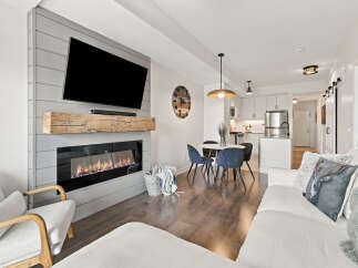 Experience modern living in this beautifully appointed open-concept space, featuring a sleek fireplace and a stylish dining area perfect for intimate gatherings.