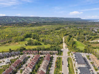 Discover modern living in this stunning aerial view of a suburban neighborhood, featuring a mix of contemporary townhouses and apartments.