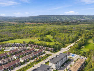 Discover modern living in this vibrant community, featuring a stunning condominium building with a private pool and adjacent townhouses offering picturesque golf course views.