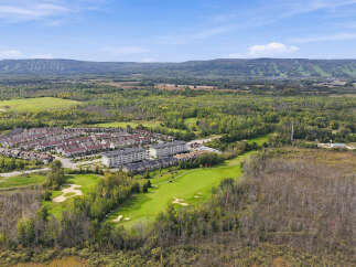Experience modern living in this stunning aerial view showcasing a vibrant community adjacent to a lush golf course.